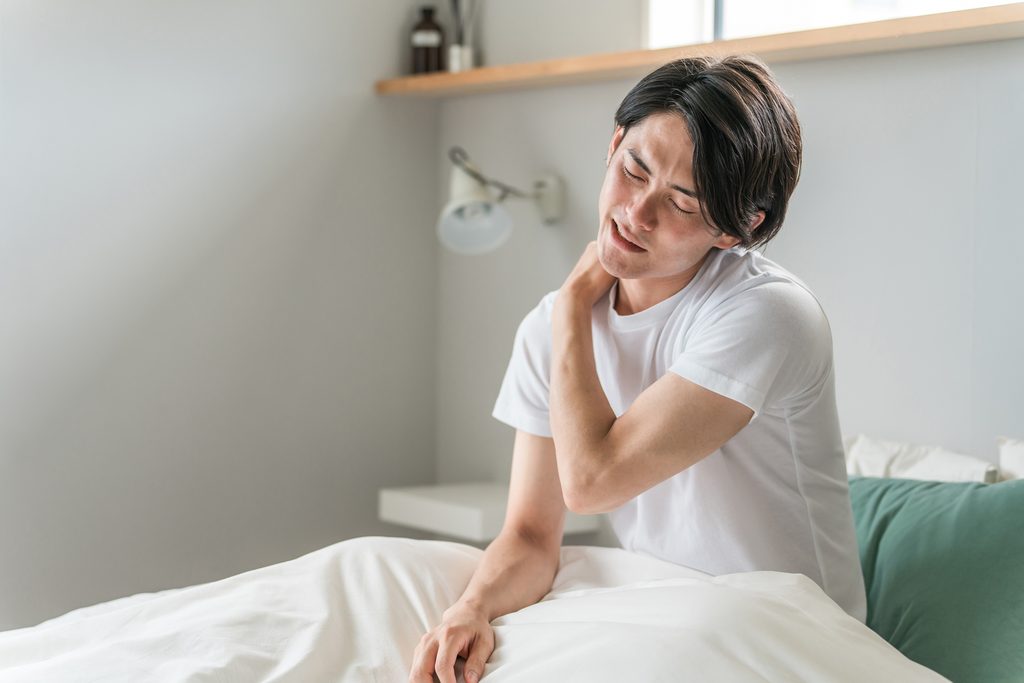 肩甲骨を押さえる男性